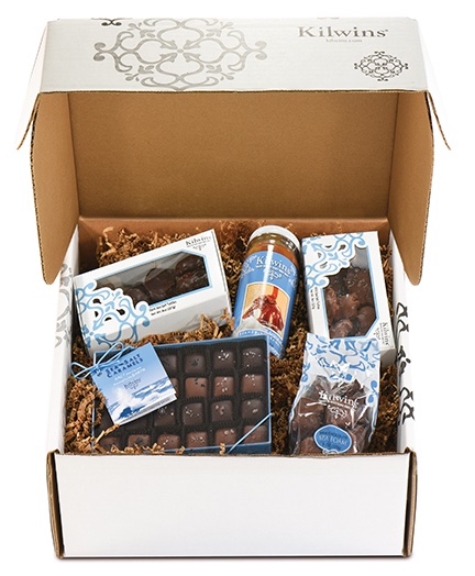 Kilwins branded gift box filled with wrapped chocolates, caramels, and treats